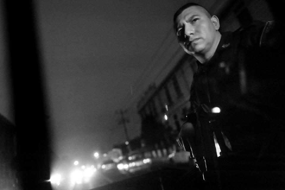  An armed policeman on a vehicle patrols in the gang neighbourhood