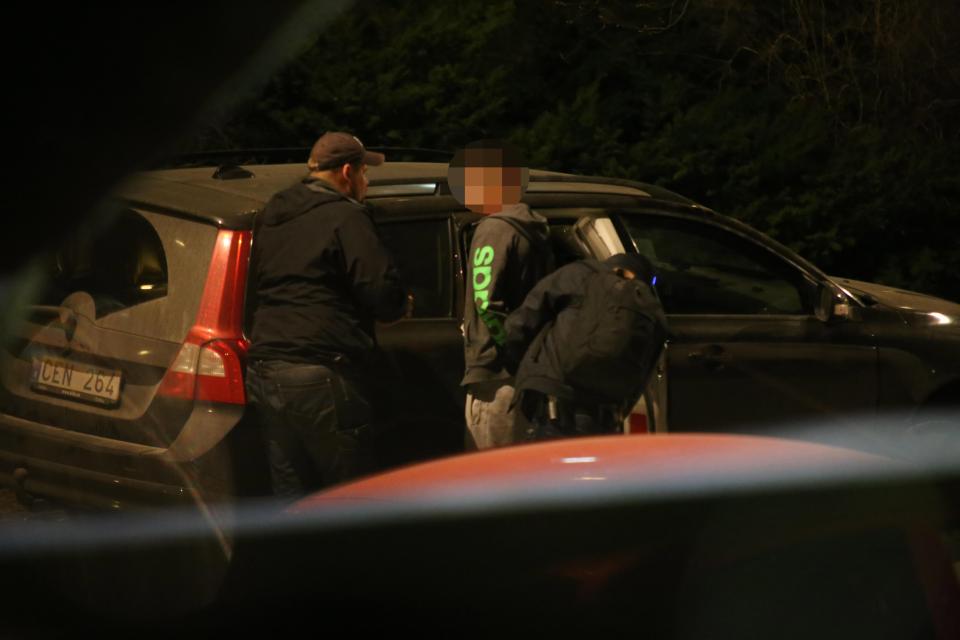 Police appear to place a man in handcuffs after a reported raid following the attack - there is no indication this man was the driver 