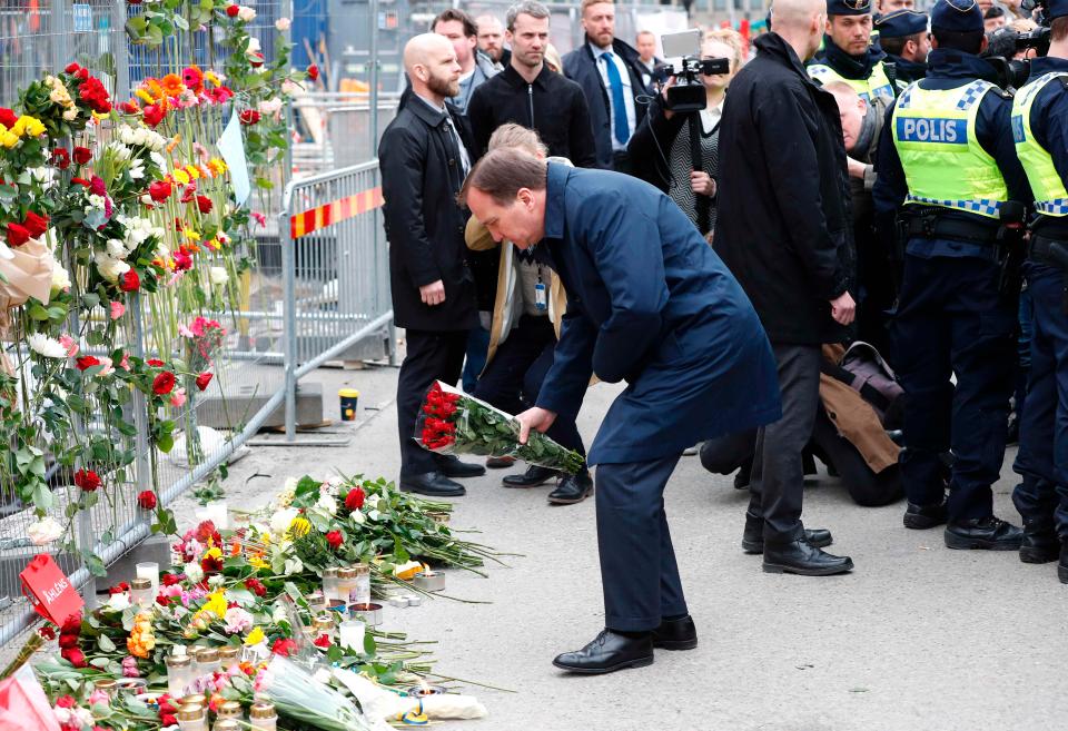 Swedish Prime Minister Stefan Lofven lays flowers at a makeshift memorial near the scene