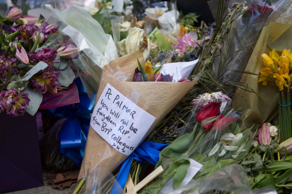 Floral tributes line the pavement as a mark of remembrance 