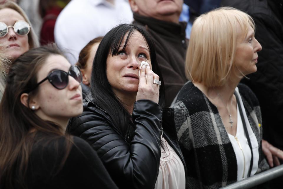 A mourner wipes away a tear during the emotional service 