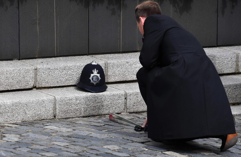 A rose is placed next to PC Palmer's police helmet near Parliament, where he lost his life