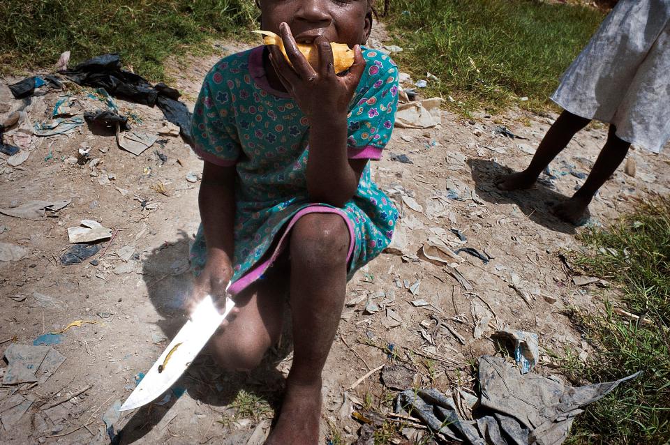  A child is eats a fruit close her home