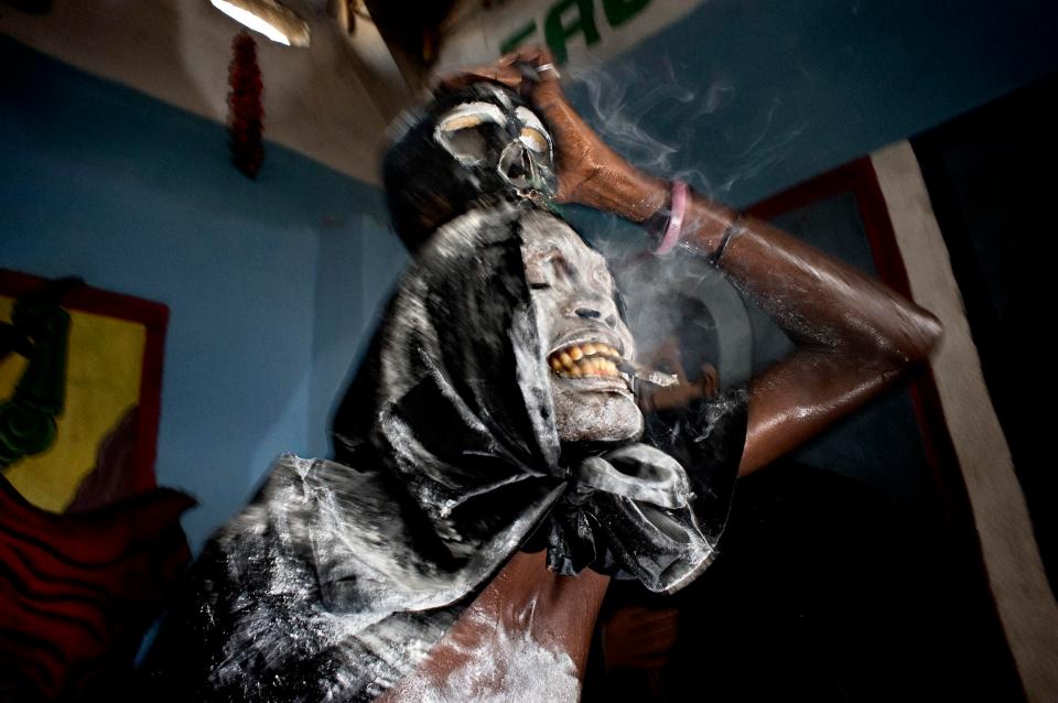  A voodoo priest plays the role of a spirit during a ceremony Sunday