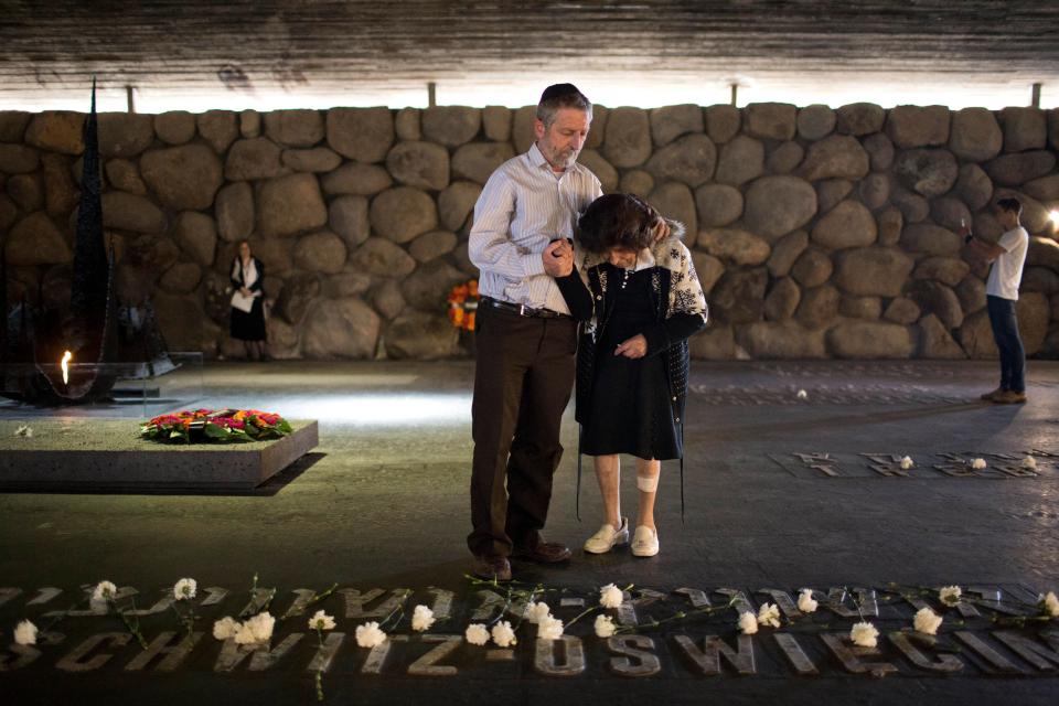  Holocaust survivor Bella Avner, right, is helped by her son to lay a flower, in memory of her family who did not survive the Holocaust, on the Auschwitz Birkenau concentration Camp memorial