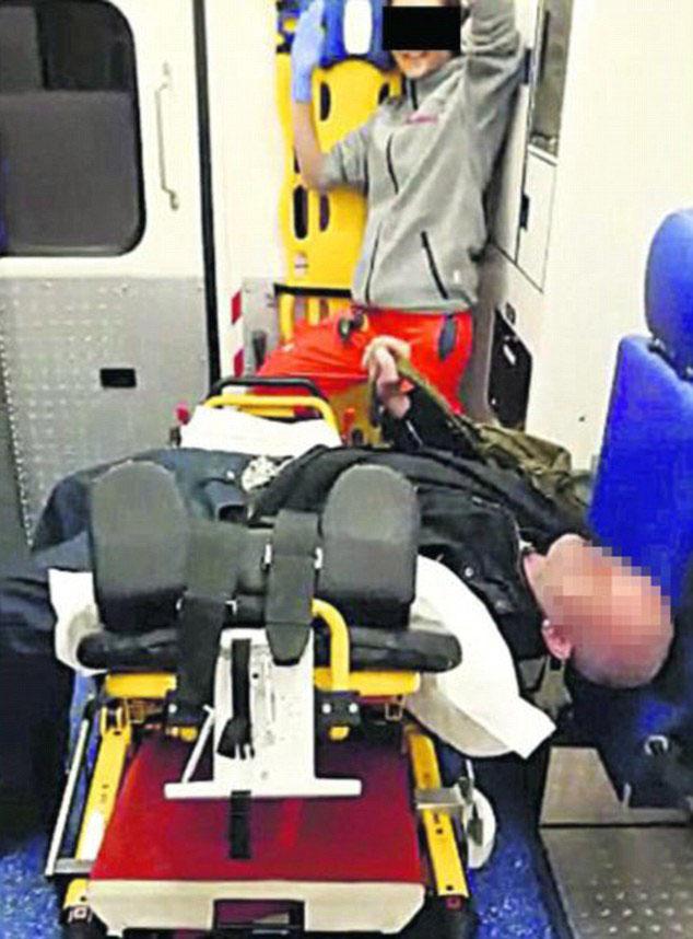 A paramedic poses in the background as a patient lays on the stretcher 