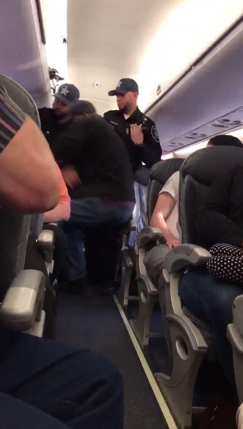  Officials were first seen trying to wrench the man from his seat