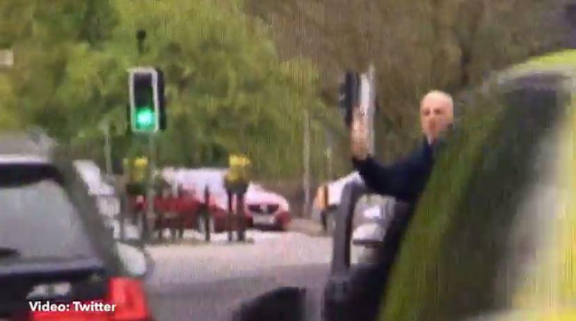 The man was seen leaning out of his car door gesturing at the PM as she passed