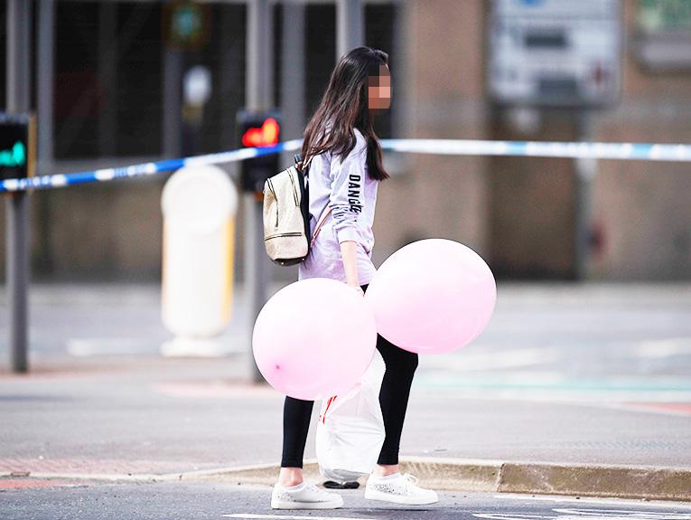  A girl walks with balloons this morning in Manchester - just outside the cordoned off area