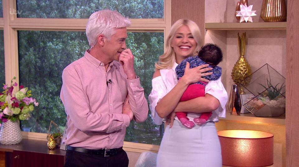  Holly looked delighted to have the three-week-old tot on her shoulder