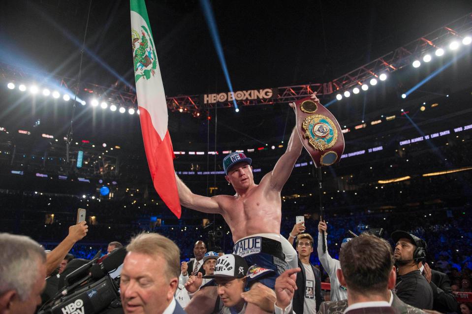  Saul 'Canelo' Alvarez raises the Mexican flag and his belt after beating Liam Smith