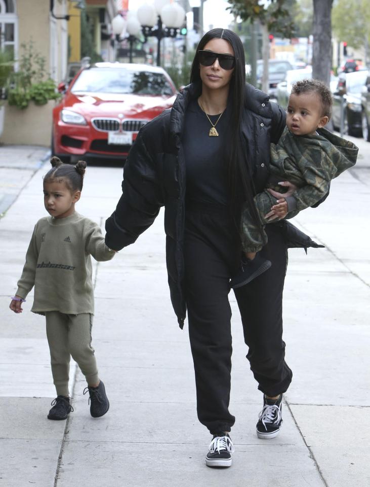  Kim with North and Saint, both wearing designer clothes she and Kanye picked out for them