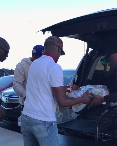 Floyd Mayweather helps pass bags of his cash to the two men to unload into his car