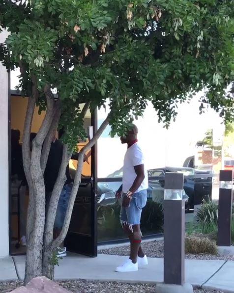 Floyd Mayweather watches as he has a trolley full of money wheeled to his car