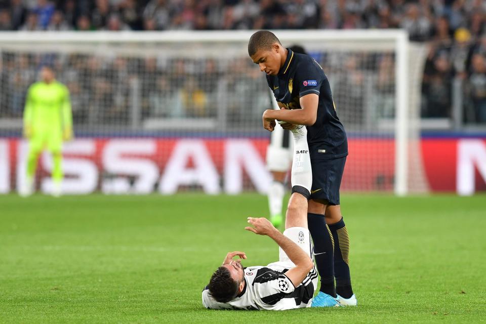  Kylian Mbappe helps out Juventus defender Andrea Barzagli who was suffering with a spot of cramp