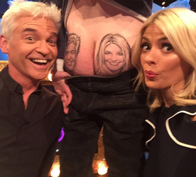  Holly Willoughby and Phillip Schofield pose next to man who had their faces tattooed on him bum cheeks