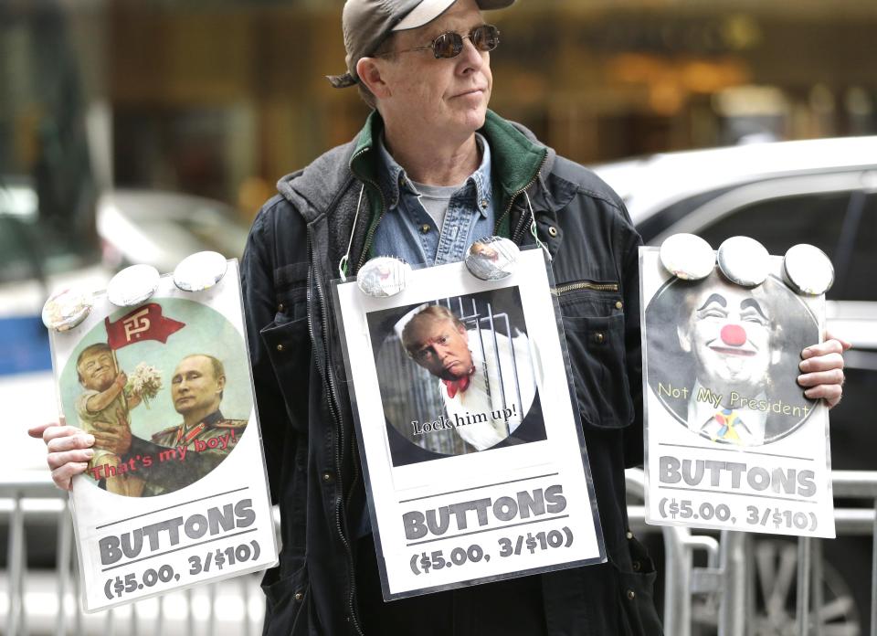  A man sells anti-Trump buttons as people participate in a protest outside Trump Tower