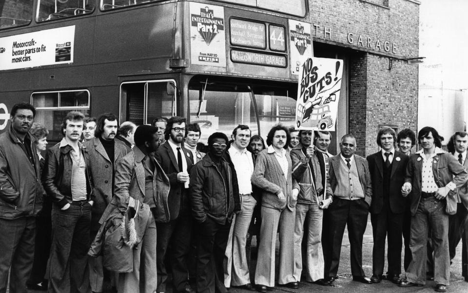  Unofficial strikers are photographed with placards outside Wandsworth bus depot in 1976. The sign reads, 'No bus cuts!'