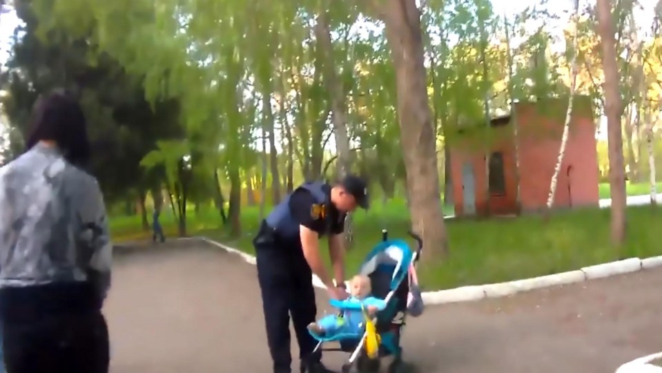 A police officer puts the youngster back in his pram