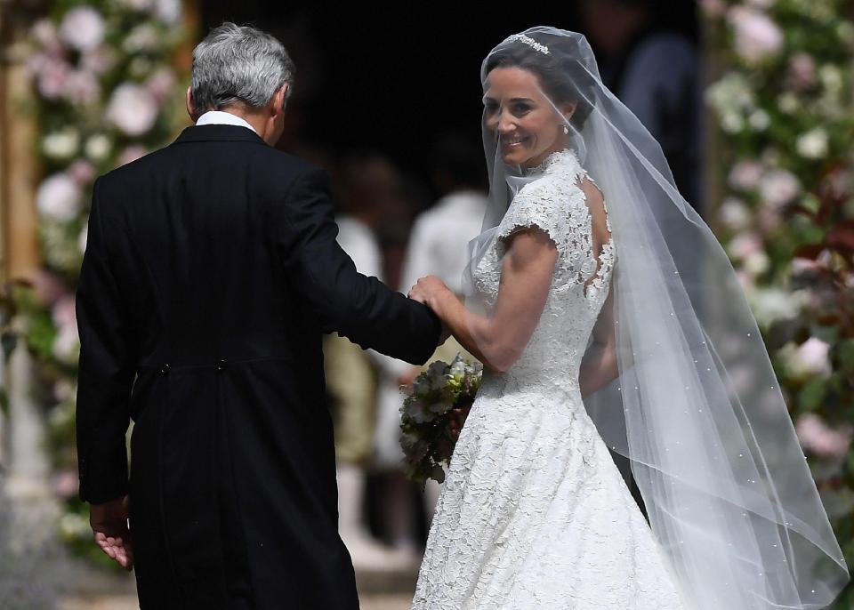  Pippa looks back for a final smile before behind escorted into church with her dad Michael