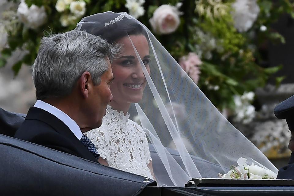  Beaming Pippa, covered by a veil, composed herself before the ceremony with her father Michael in open-top car