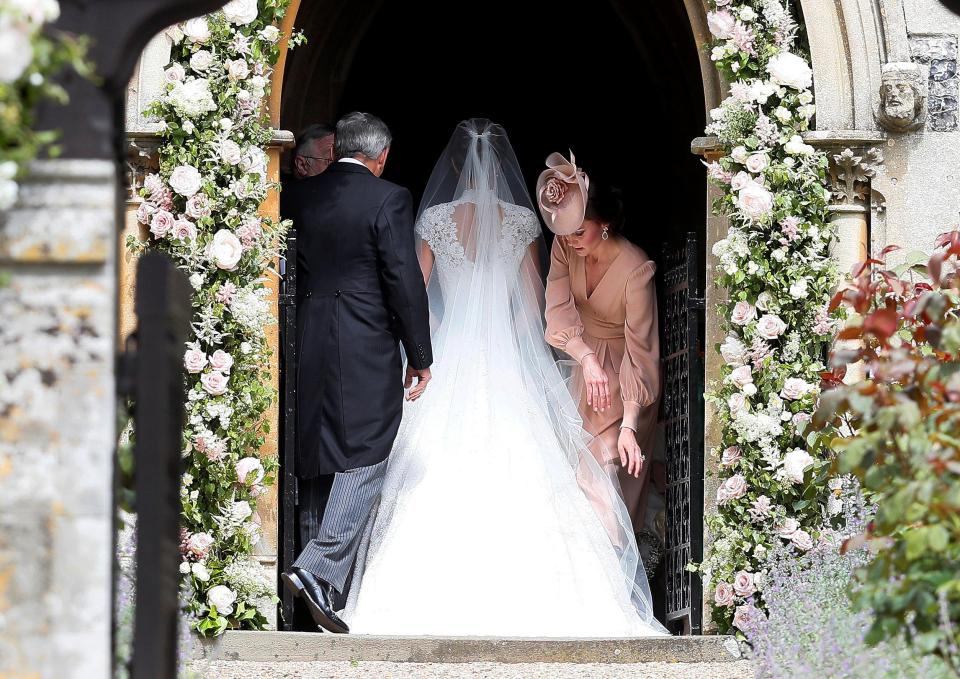  The Duchess of Cambridge was on hand to smooth out little sister Pippa's dramatic ivory lace train