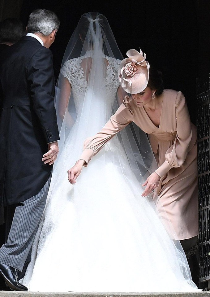 Kate was seen smoothing out her sister’s dramatic train before she made her way into the church on the arm of her father Michael Middleton