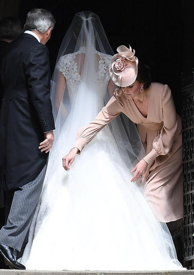  Kate was seen smoothing out her sister's dramatic train before she made her way into the church on the arm of her father Michael Middleton