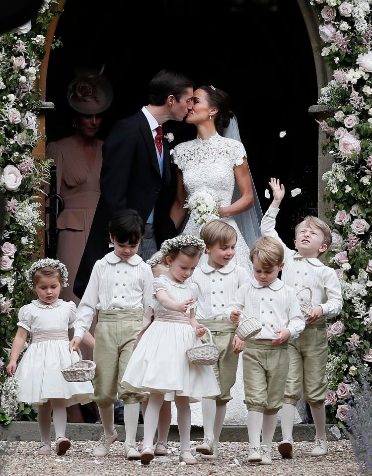  James Matthews and Pippa Middleton kiss as they stand outside picturesque church behind adorable flower girls and page boys