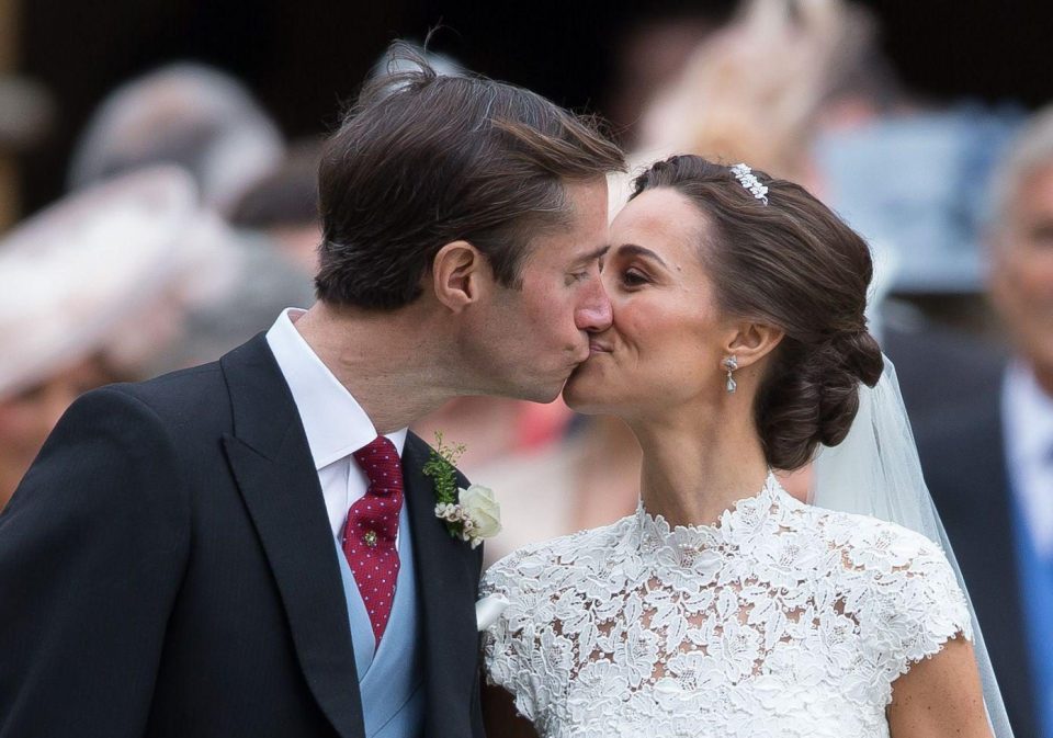  The bride and groom share a case in front of photographers and well-wishers