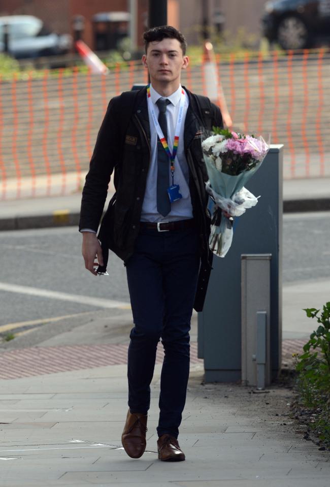  A man carries some flowers to the scene of where 22 concert-goers have been reported killed