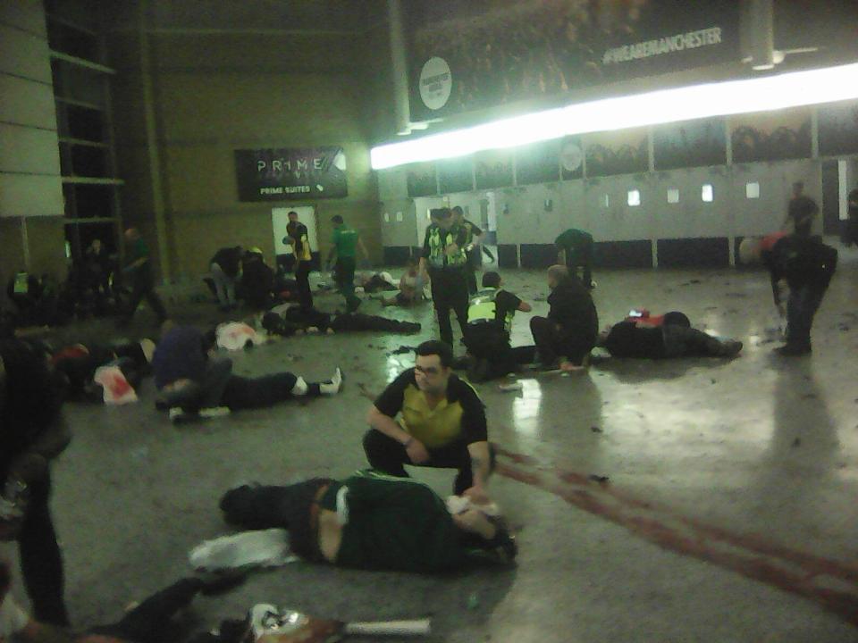  Helpers attend to people inside the Manchester Arena after a suspected suicide bomber detonated an explosive device