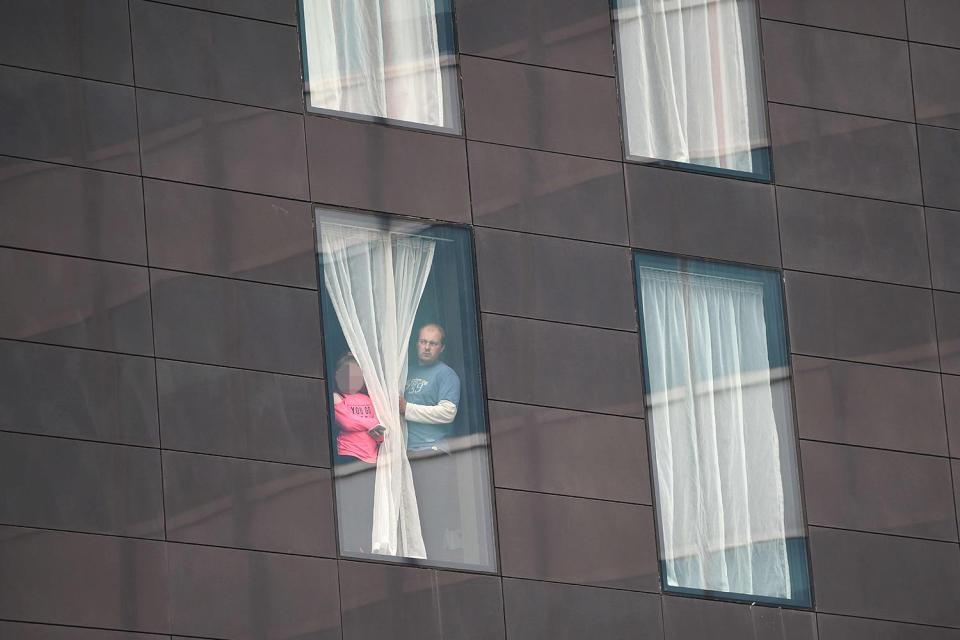 Two people affected by the attack look out from the window of a Manchester hotel room