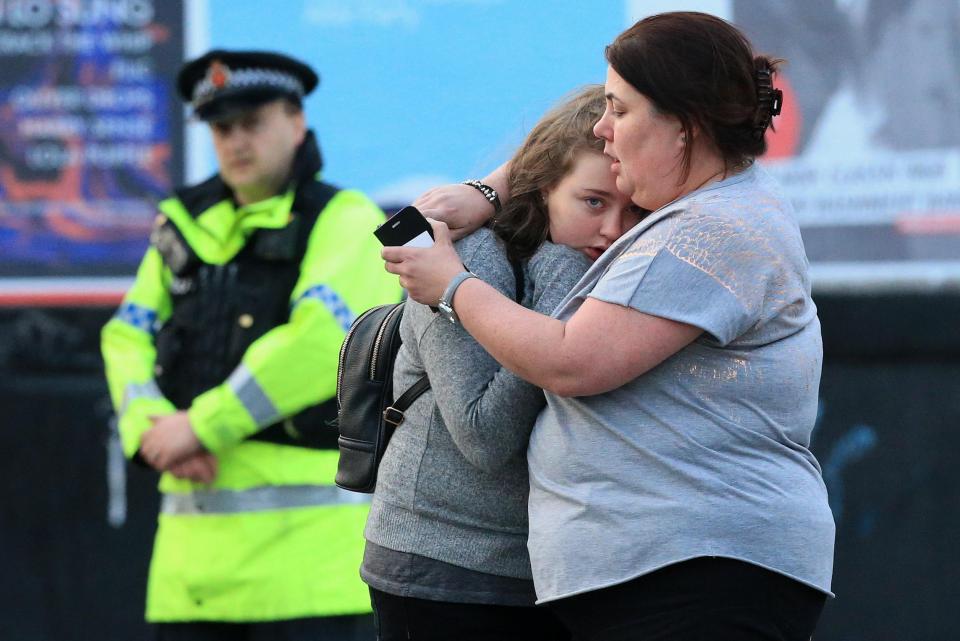  Walking casualties Vikki Baker and her daughter Charlotte, 13, hug outside the Manchester Arena stadium