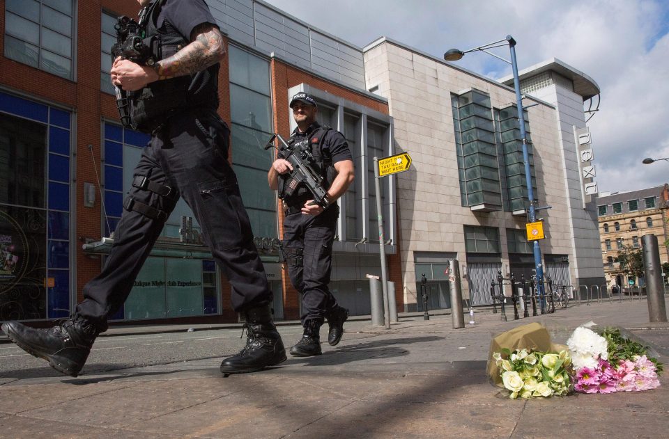 Tributes left at the scene in Manchester as armed police patrol 