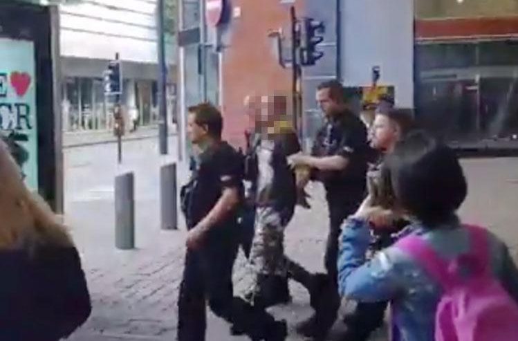 A man was seen being led away, surrounded by armed police 