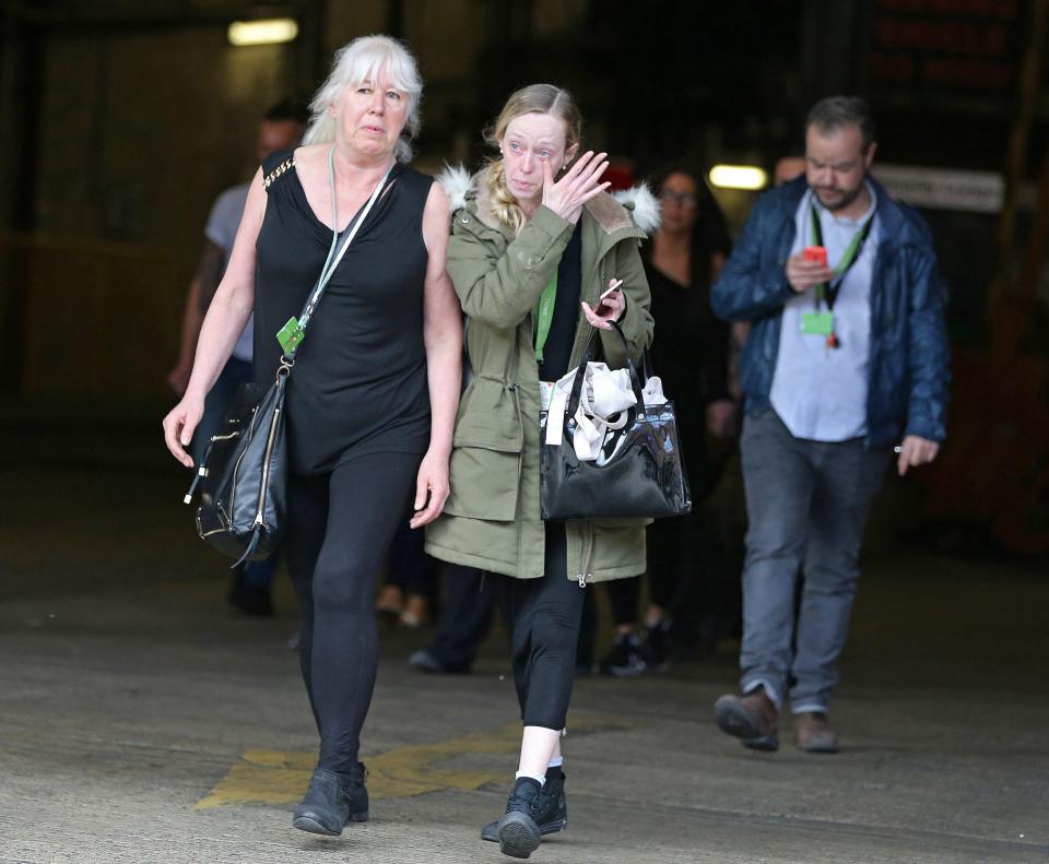 A woman wipes away tears while fleeing from the centre this morning 