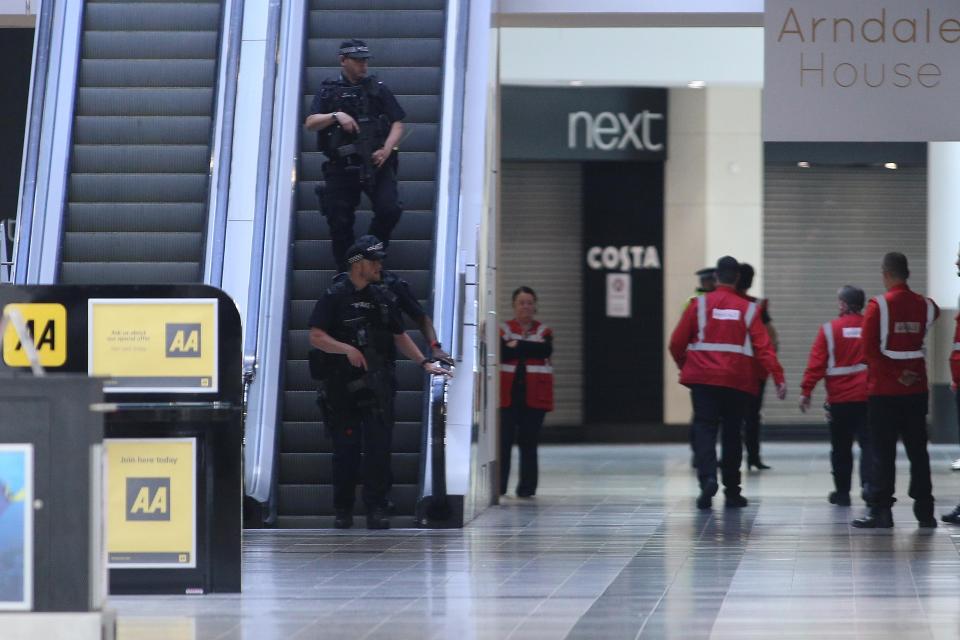 Armed police are seen inside the centre after it was locked down today 