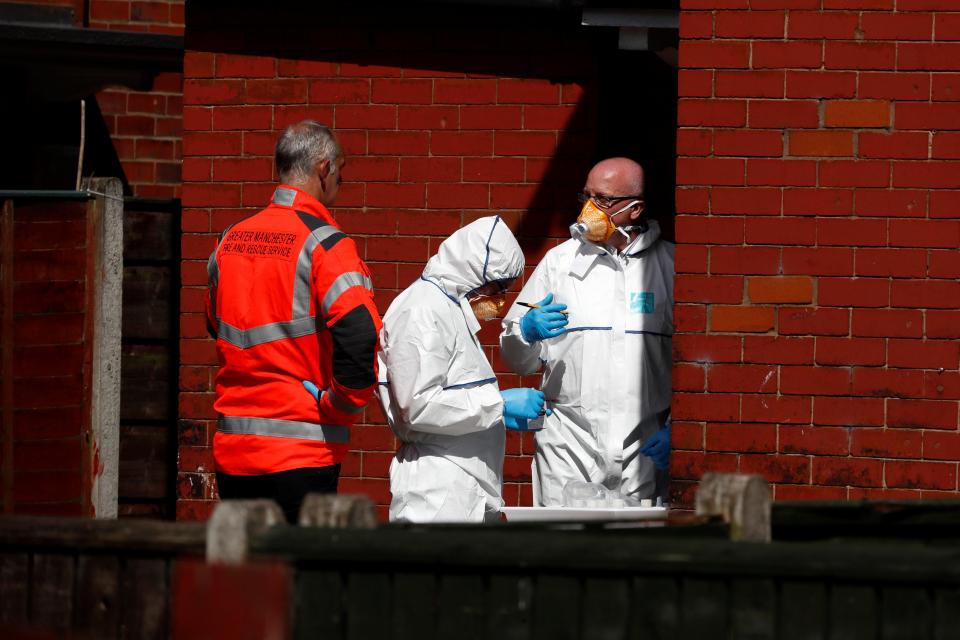 Forensic officers are seen at the scene of the raid today