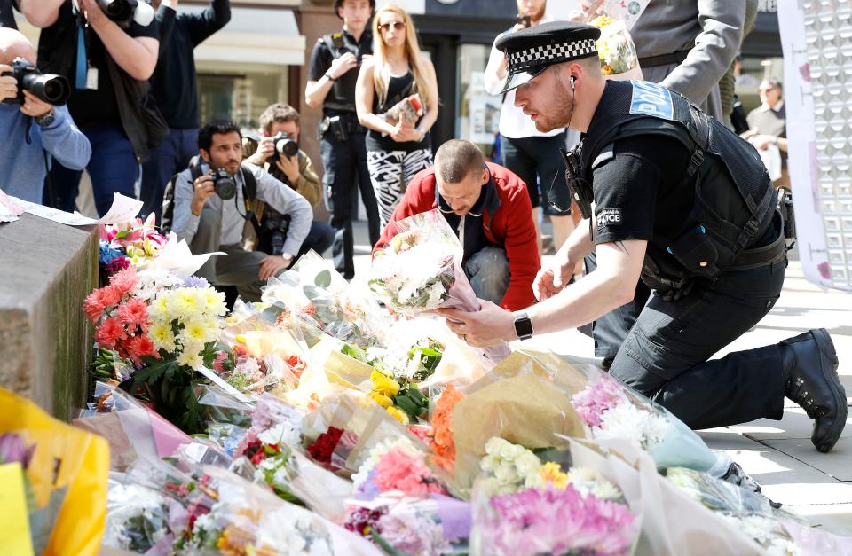  Police are pictured laying flowers in tribute to the victims of the Manchester bombing