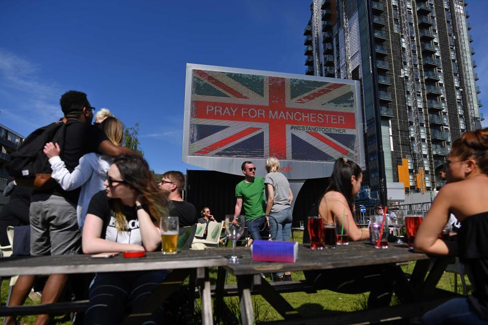 An electronic advertising board displays a union flag and the words Pray For Manchester near to the arena today