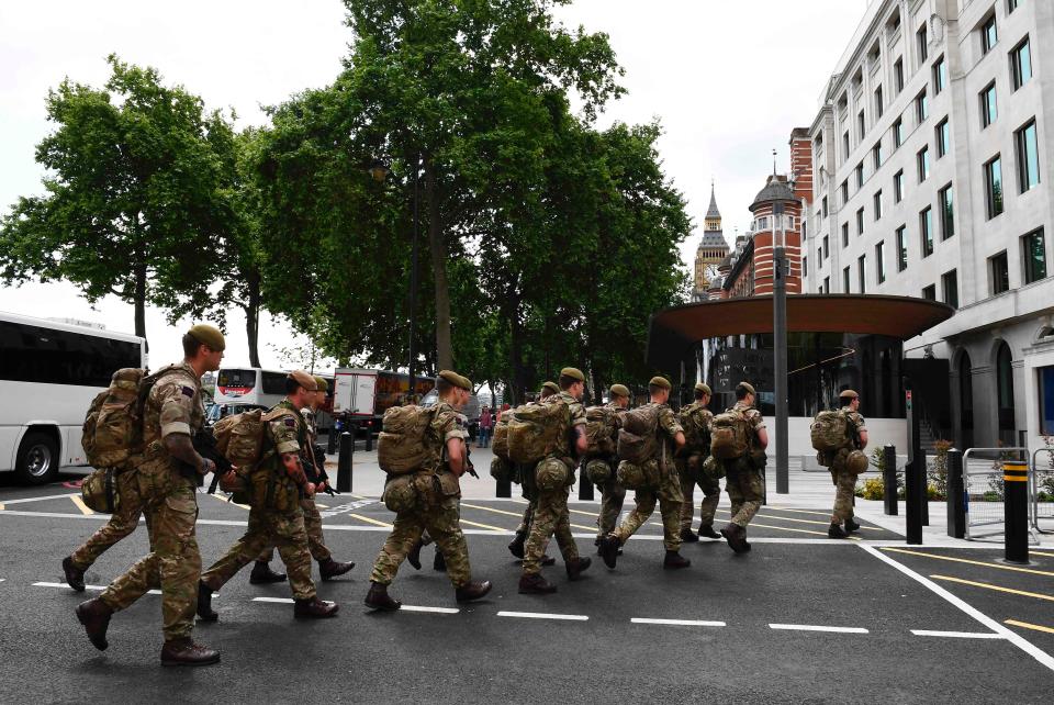  British soldiers arrive by bus and head toward a building next to New Scotland Yard police headquarters near to the Houses of Parliament