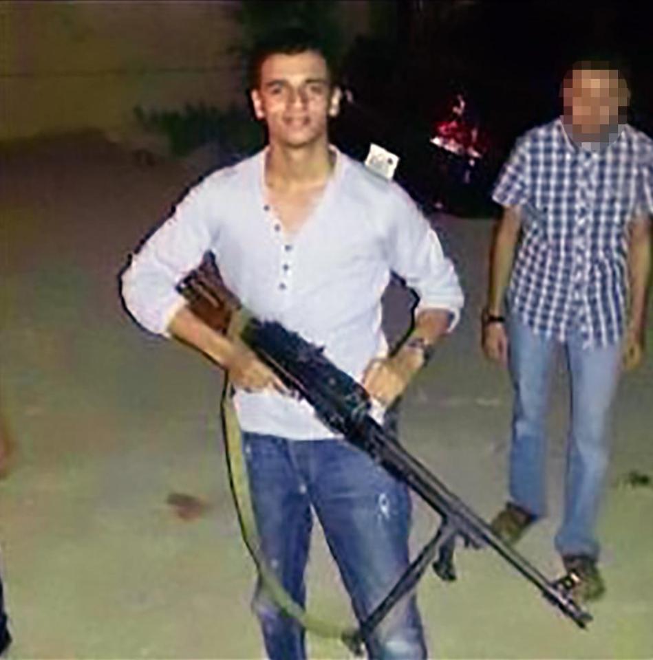 Ishmail Abedi poses for a picture with a machine gun