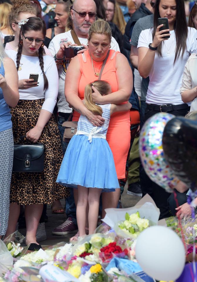  A young girl gets a supportive hug as she attends vigil at St. Ann's Square in Manchester this morning