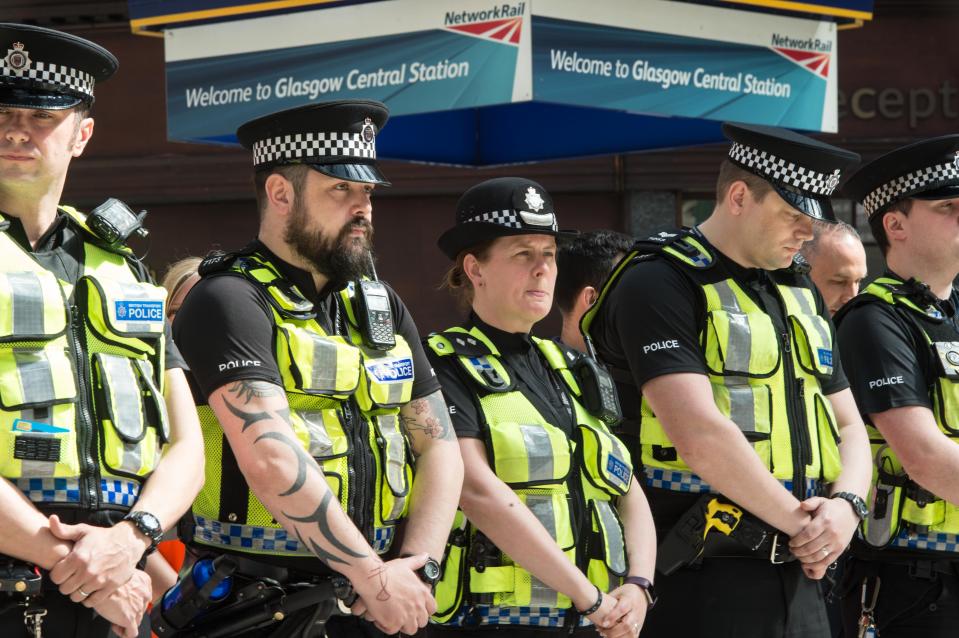  Police officers pause and reflect during the minute's silence at Glasgow Central Station