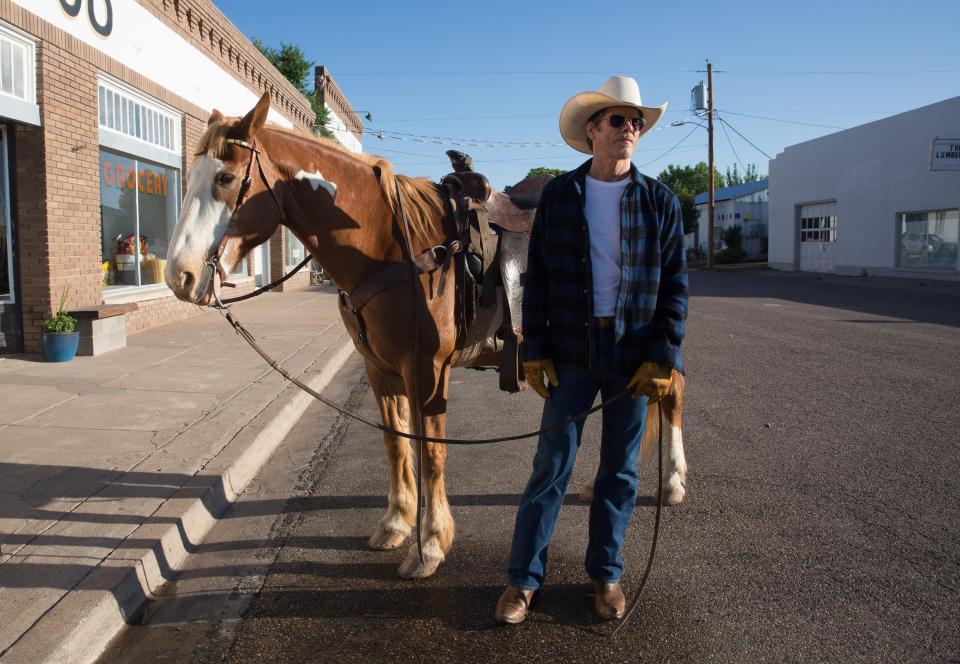  Artist Dick stands with his horse in a small town street