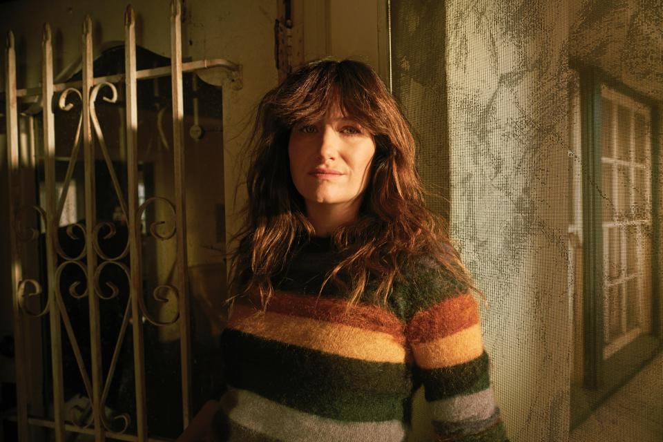  Chris played by Kathryn Hahn stands in a shadowed doorway