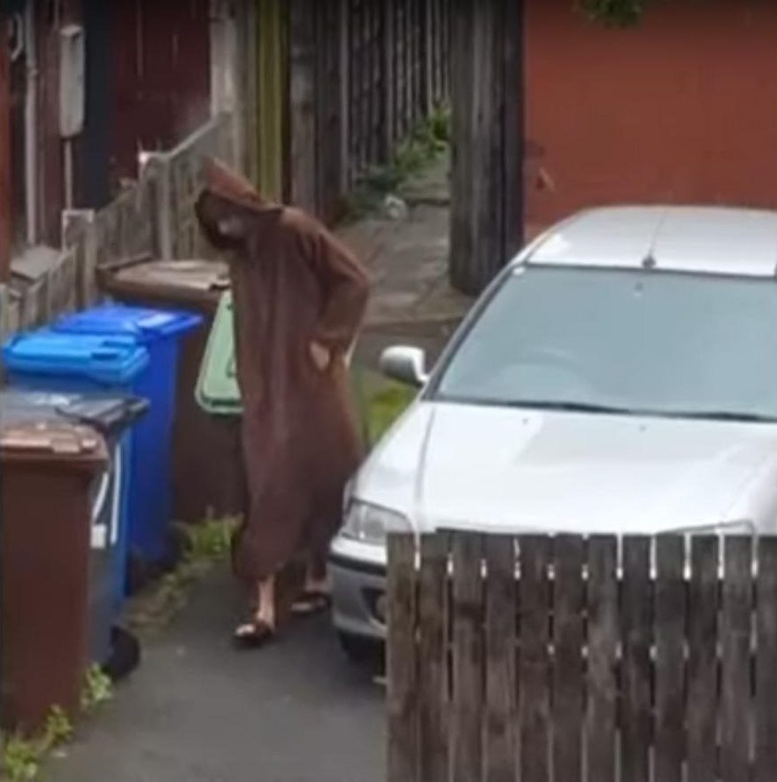  He is seen dressed in a brown robe with the hood pulled up, as he wheeled out bins to the front of his Manchester house