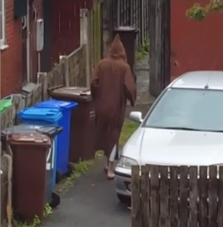  He was filmed wearing a brown hooded robe on what looked like a rainy day