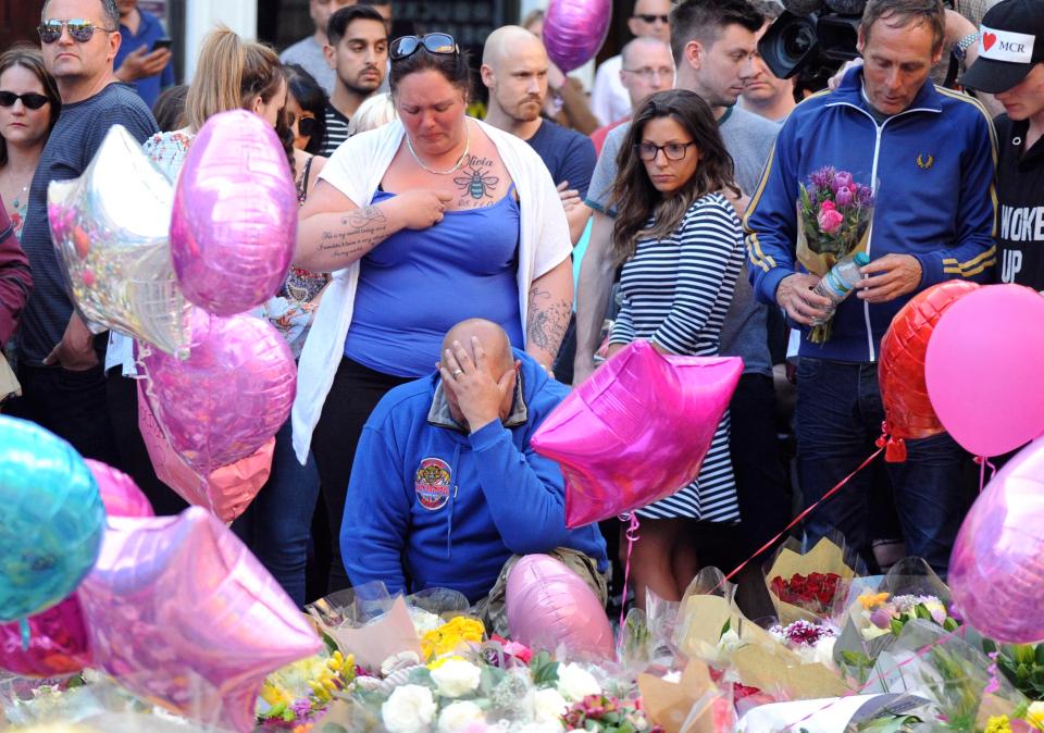  Olivia Campbell's mother Charlotte Campbell, centre and stepfather Paul Hodgson, foreground, pay tribute to the victims of the explosion outside Manchester Arena